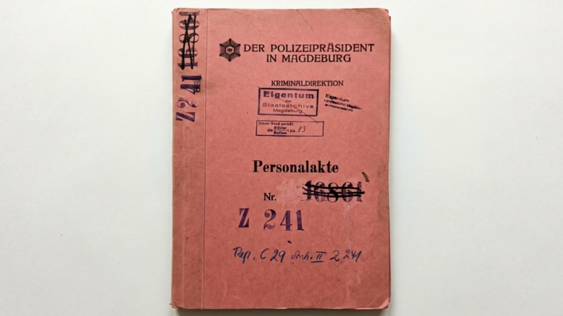 Film still: a pink German police personal file marked Personalakte Z 241, stamped by the Police President in Magdeburg