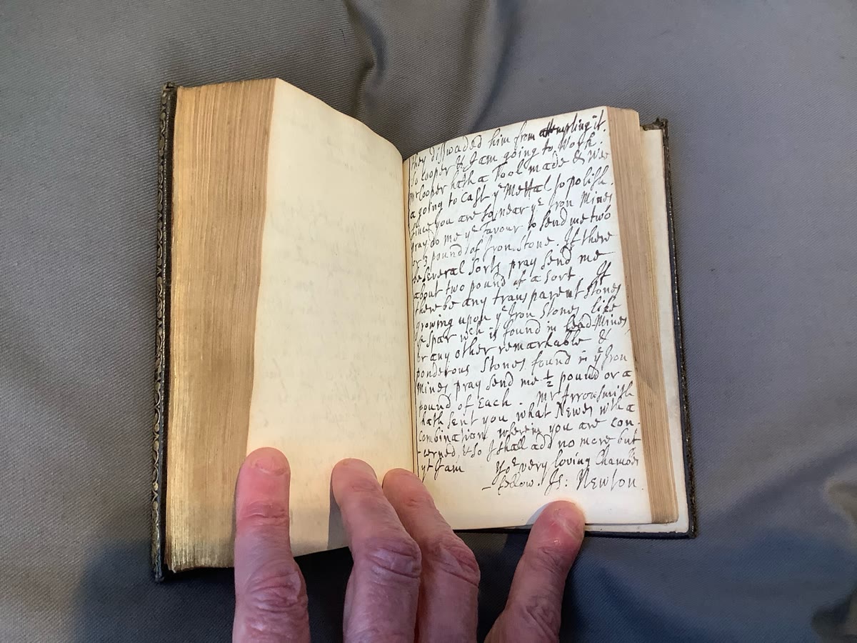 A handwritten notebook page signed by Isaac Newton
