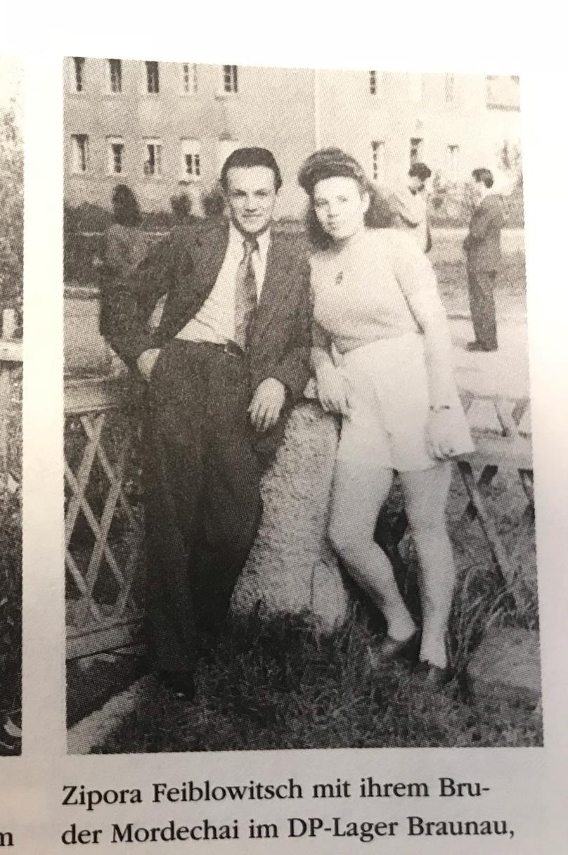 Archival photograph: Zippora and a man leaning on a fence in a displaced persons camp